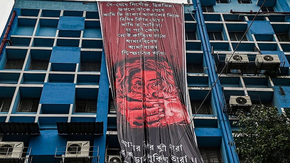 | Photo: PTI : Kolkata rape-murder case: Junior doctors hang a giant poster from the roof of the R G Kar College